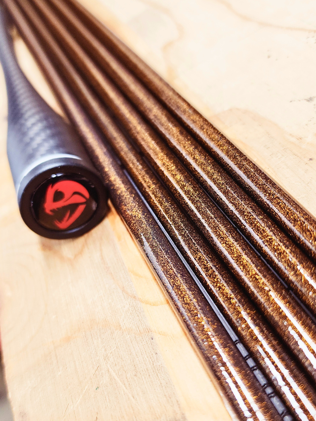Canne Alpha Carbon par Cannes Boréal – vue du bout de la poignée avec logo et tubes en finition cuivrée, illustrant la précision et la qualité de fabrication.