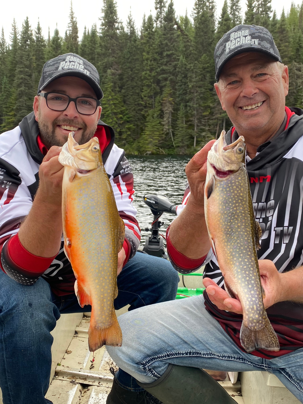 Norman Byrns et Kenny tenant une truite capturée avec la canne Signature Norman Byrns Truite par Cannes Boréal – performance et précision en action.